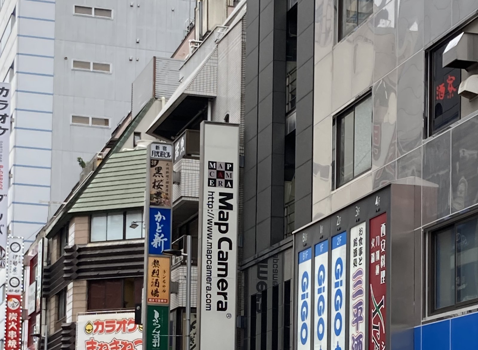 Map Camera's tall sign on the street in Shinjuku