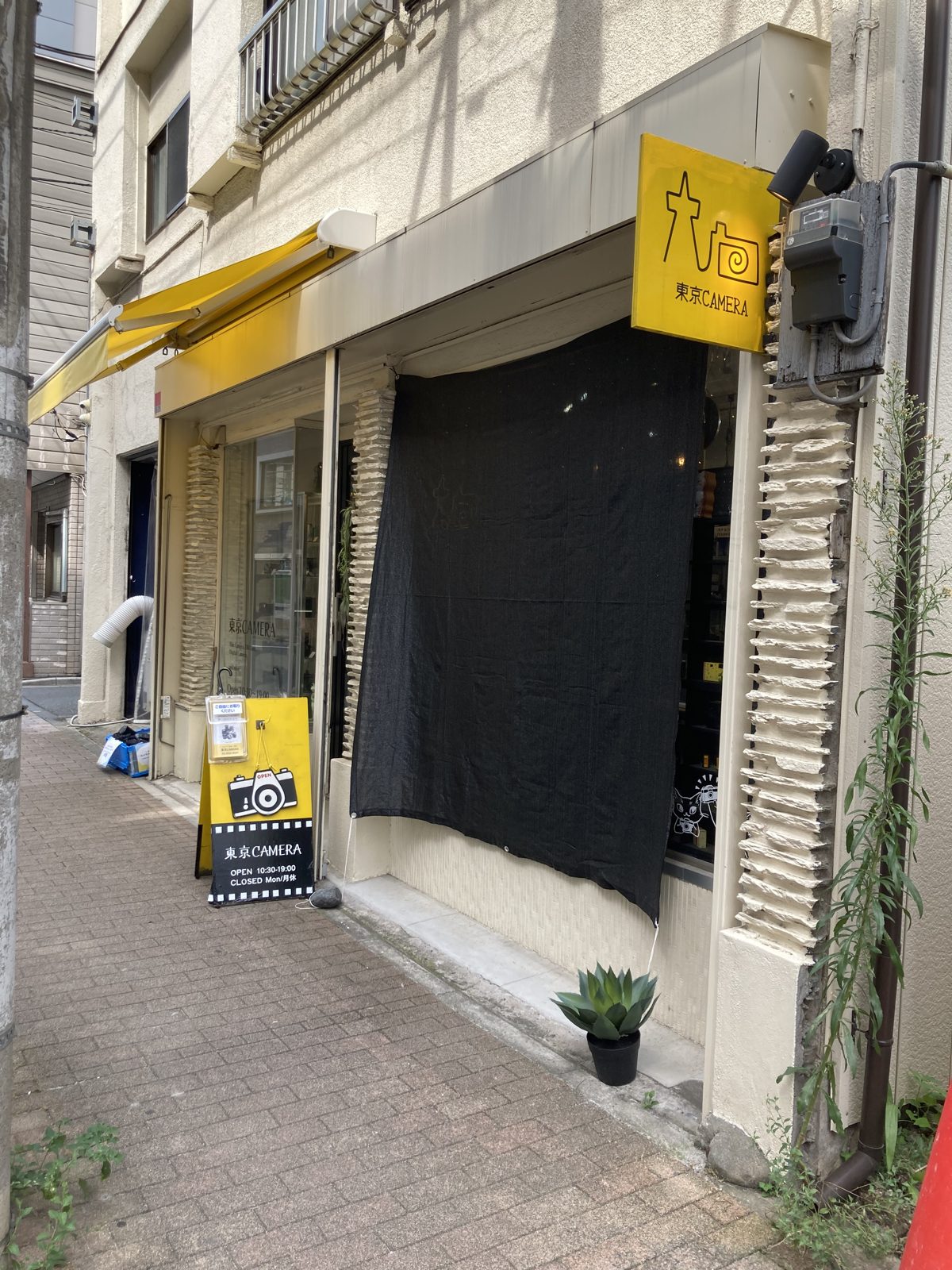 Tokyo CAMERA in Akihabara, with a yellow awning and a camera logo