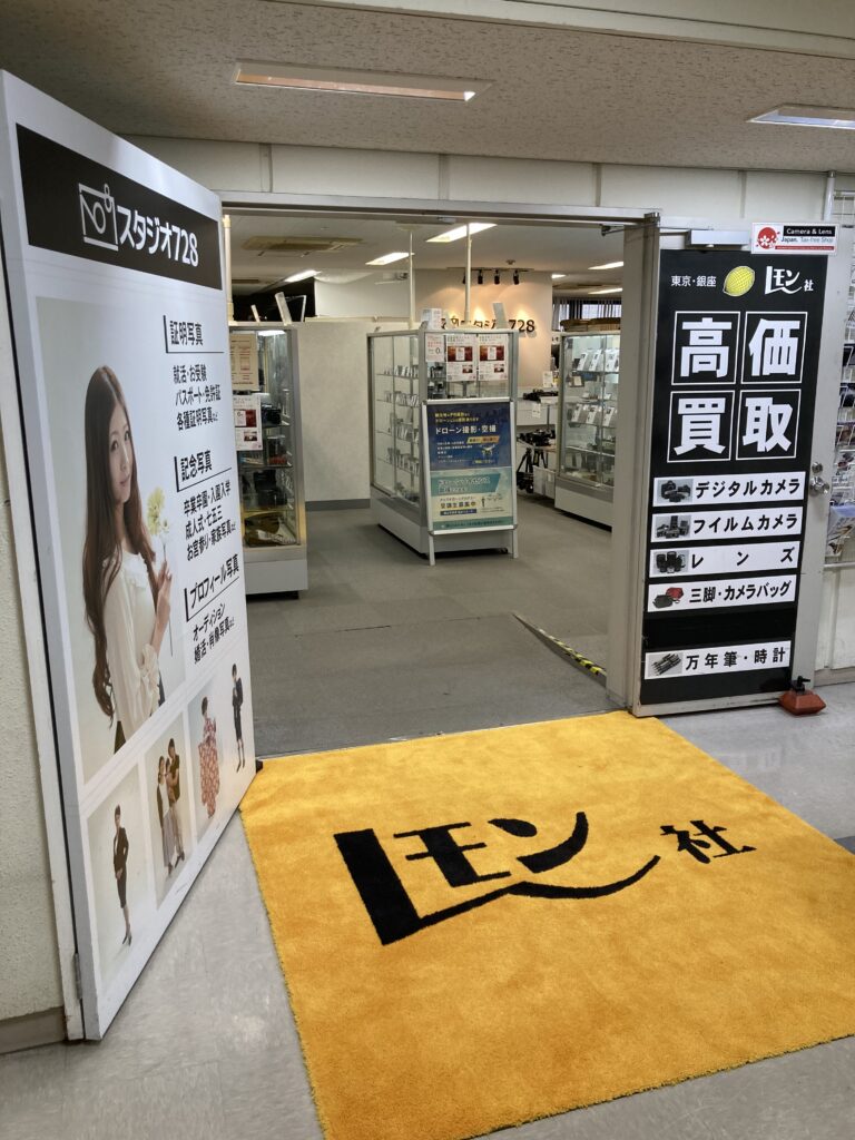 Lemon Camera Ginza shopfront on the 8th floor, with its yellow logo mat and Tax-free Shop sticker