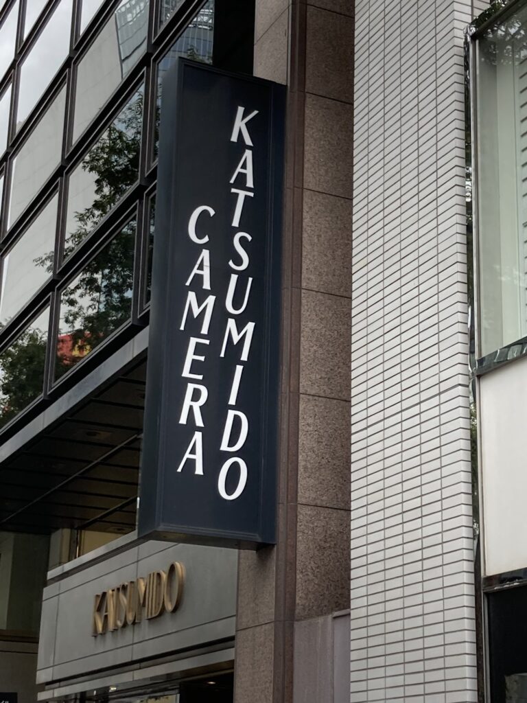 Tall black Katsumido Camera sign with the gold Katsumido logo in Ginza