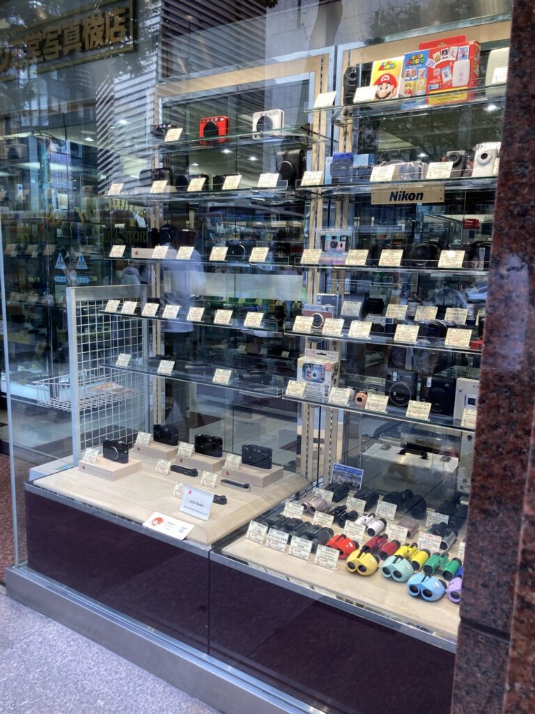 Katsumido Camera's show window in Ginza, with price tags, a Leica Dealer plate and a Japan Tax-free Shop sticker