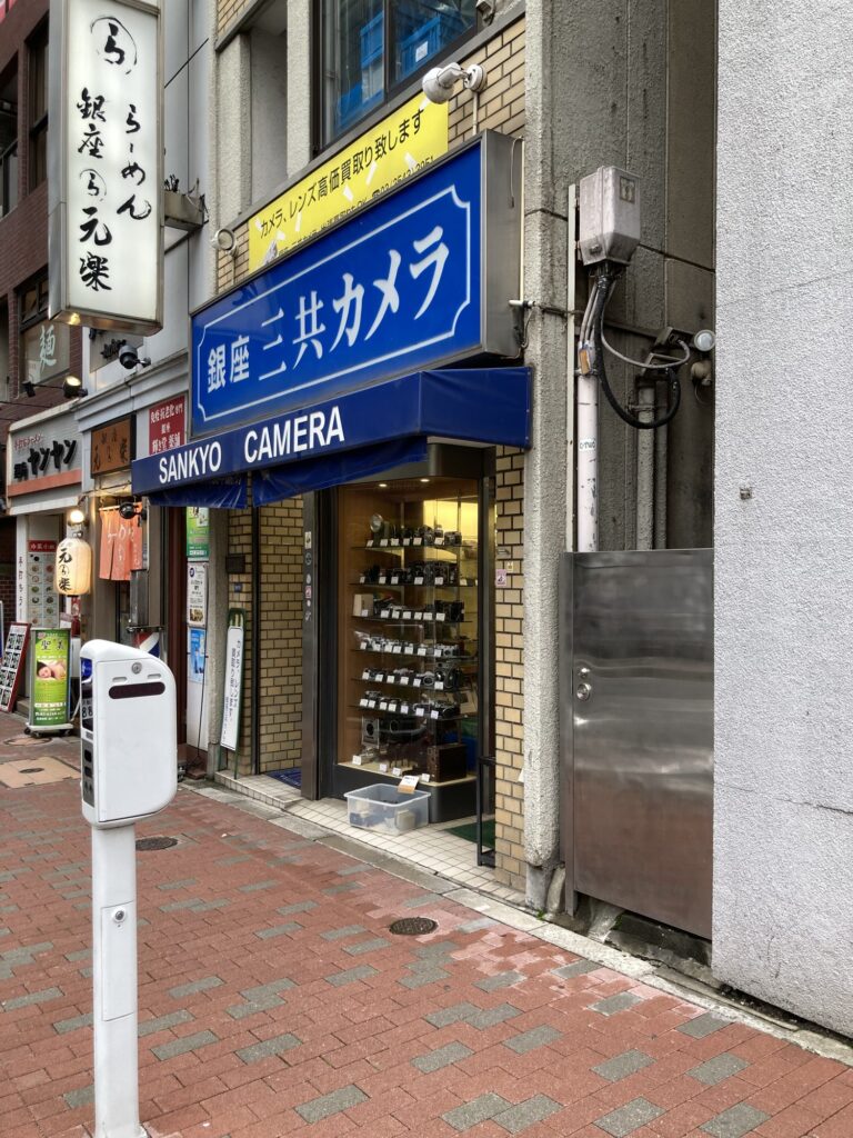 Sankyo Camera storefront in Ginza with a yellow sign saying they buy cameras and lenses